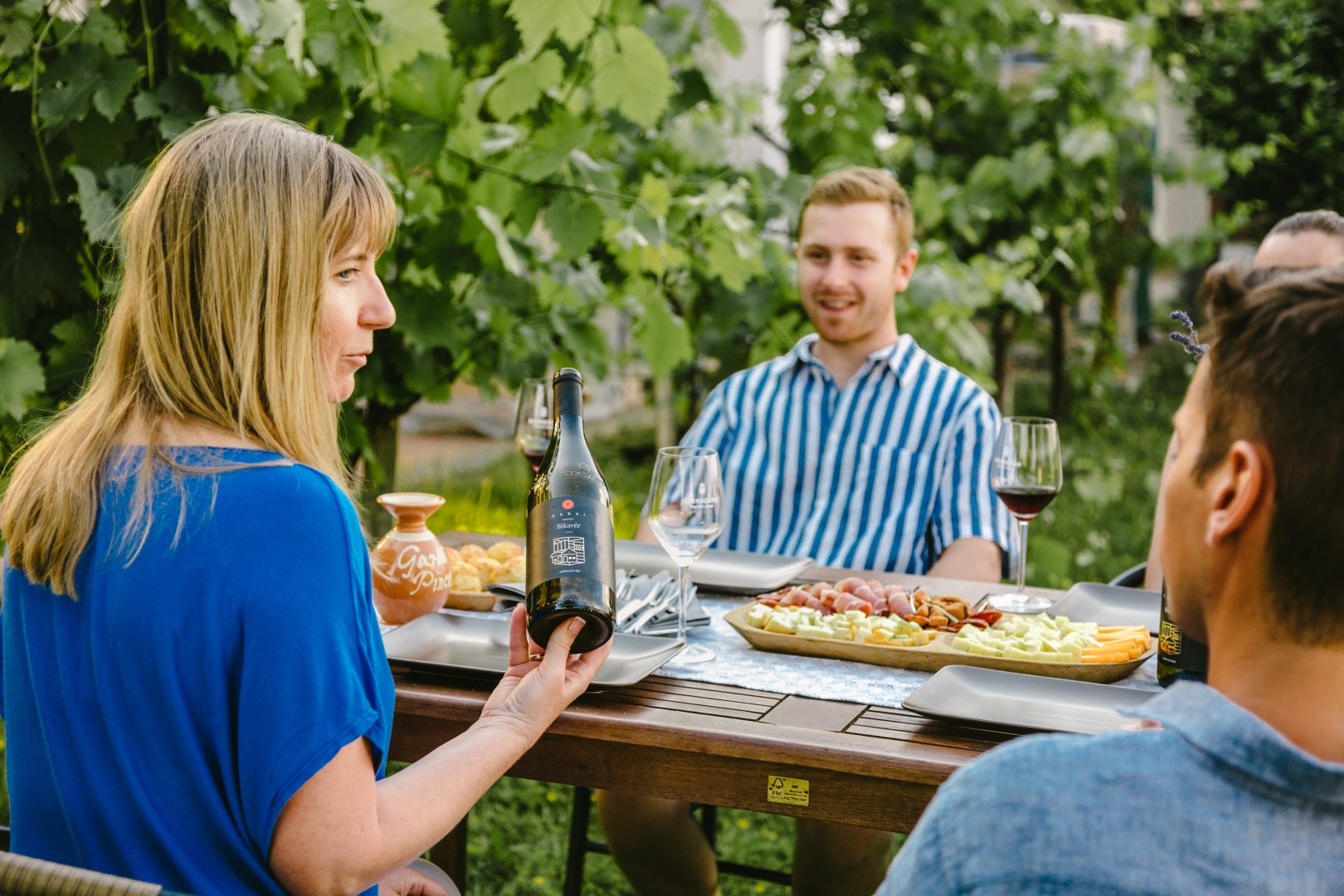 Friends drink red wine with cold cuts at Garai Winery in Szekszárd