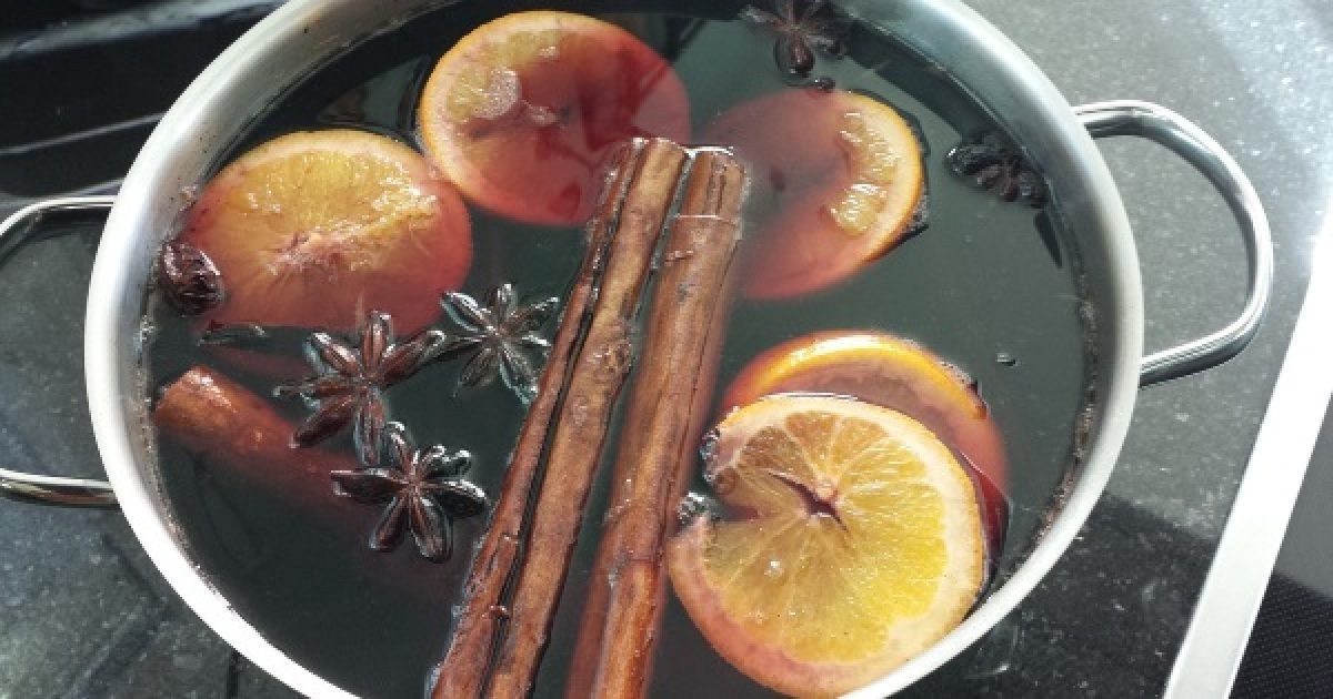 Wine, spices and orange slices turining into mulled wine